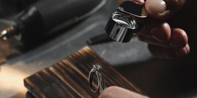 Professional jeweler working with ring at table, closeup